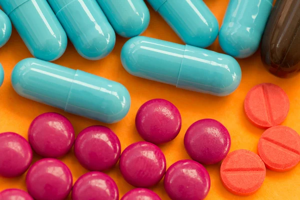 Colorful pills on orange background. — Stock Photo, Image