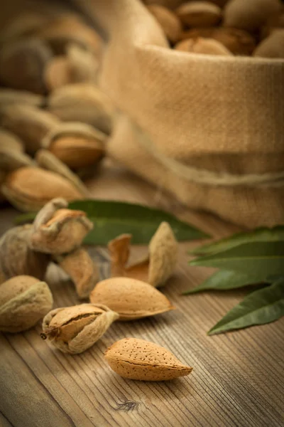 Almendras sobre fondo de madera marrón — Foto de Stock