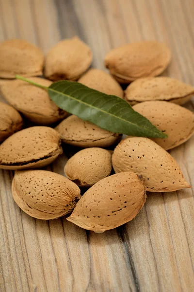 Almendras sobre fondo de madera marrón — Foto de Stock