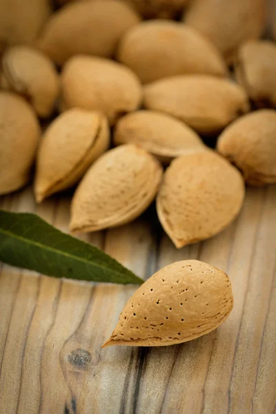 Almendras sobre fondo de madera marrón — Foto de Stock