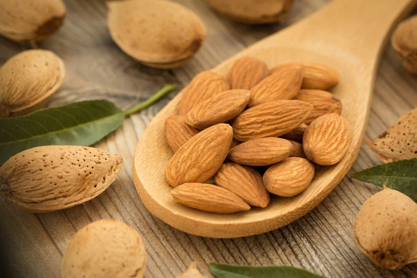 Almond seeds on wooden table — ストック写真