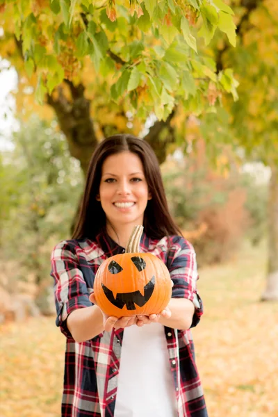Menina no parque com abóbora de Halloween — Fotografia de Stock