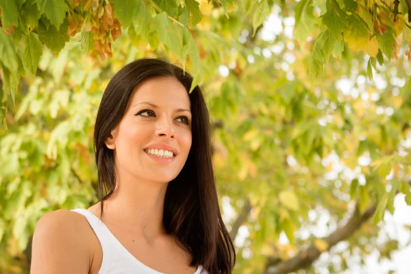 Brunette relaxing in autumn park — Stock Photo, Image