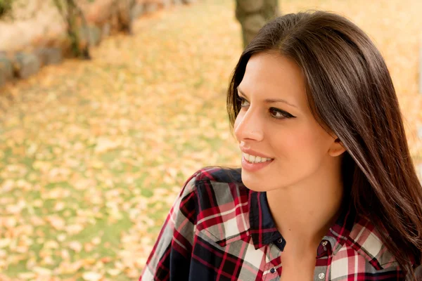 Brunette relaxing in autumn park — Stock Photo, Image