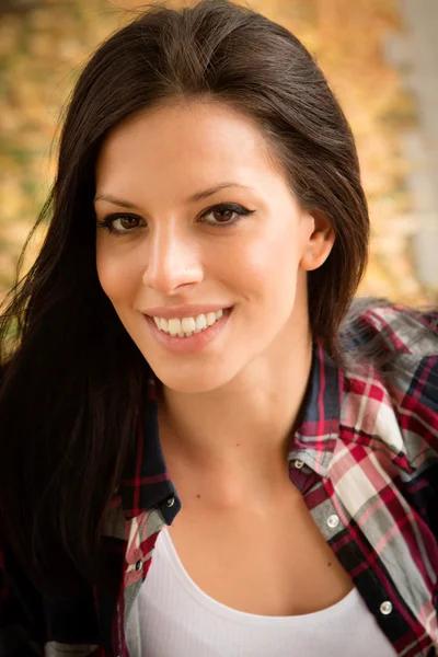 Brunette relaxing in autumn park — Stock Photo, Image