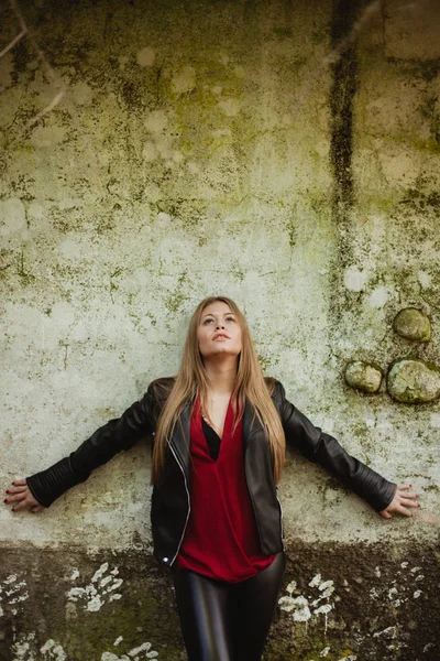 Blond meisje op grunge muur — Stockfoto