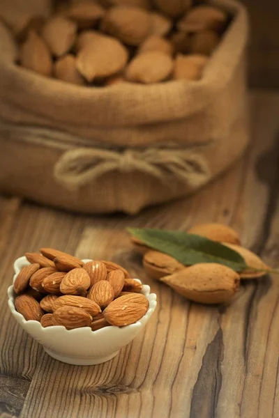 Amandelen op bruin houten tafel — Stockfoto