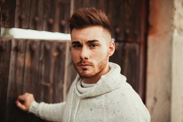 Attractive guy opening an old door — Stock Photo, Image