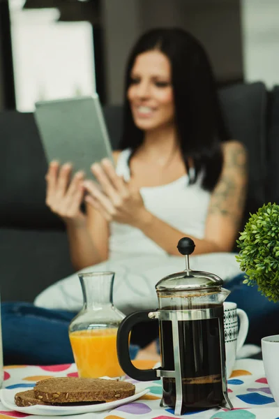 Žena při snídani a čtení tabletu — Stock fotografie
