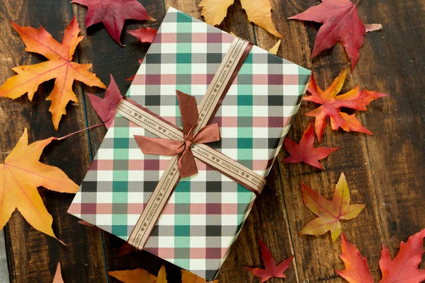 Красивый подарок с осенними листьями — стоковое фото