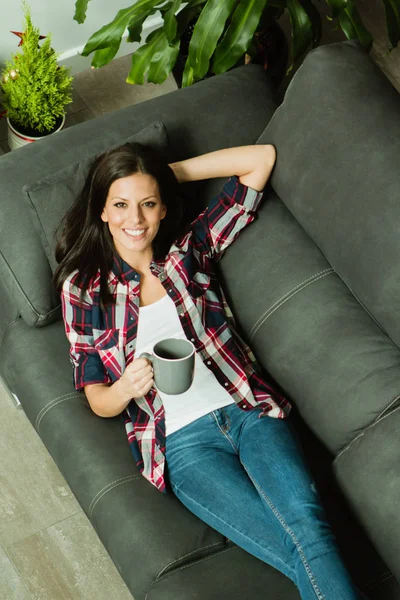 Frau mit Tasse auf Sofa — Stockfoto