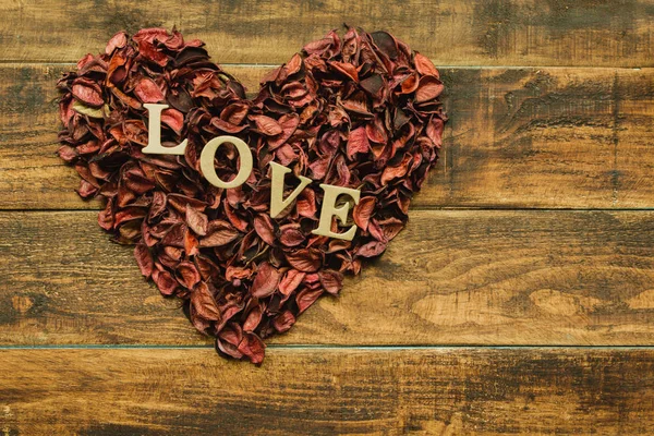 Beautiful heart made with dry petals — Stock Photo, Image