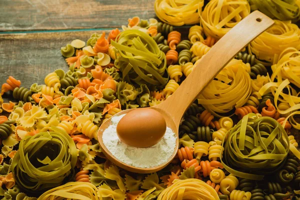 Färgad pasta med ägg i sked — Stockfoto