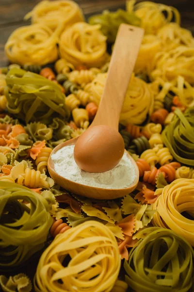 Gekleurde pasta met ei in een lepel — Stockfoto