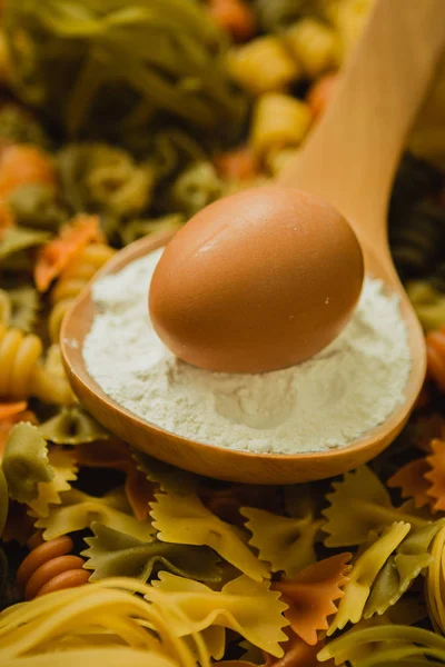 Färgad pasta med ägg i sked — Stockfoto