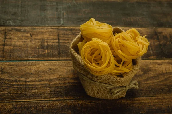 Dry pasta on wooden table — Stock Photo, Image