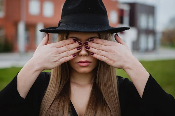 Дівчина з капелюхом, що закриває обличчя руками — стокове фото