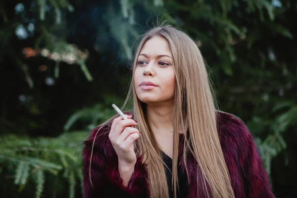 Bella ragazza che fuma nel parco — Foto Stock