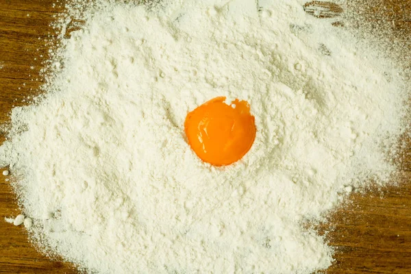 Egg yolk on pile of flour — Stock Photo, Image