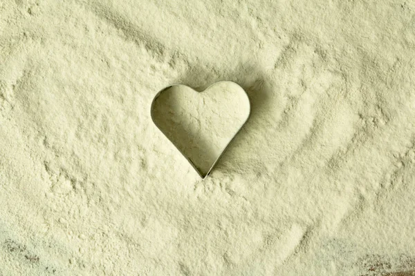 Heart shape cutter on flour — Stock Photo, Image