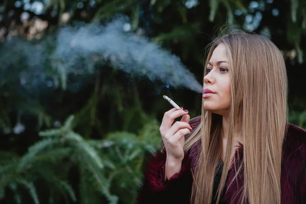 Bella ragazza che fuma nel parco — Foto Stock