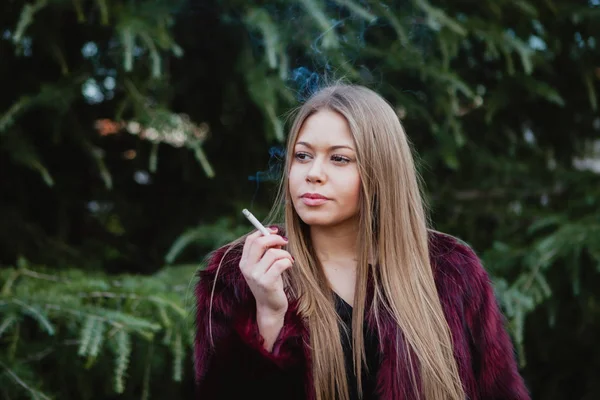 Красива дівчина палить в парку — стокове фото