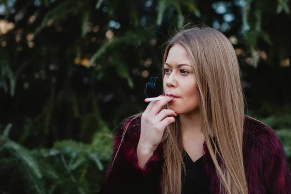 Bella ragazza che fuma nel parco — Foto Stock