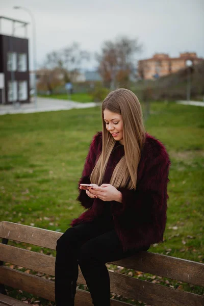 Femme dans le parc avec téléphone portable — Photo
