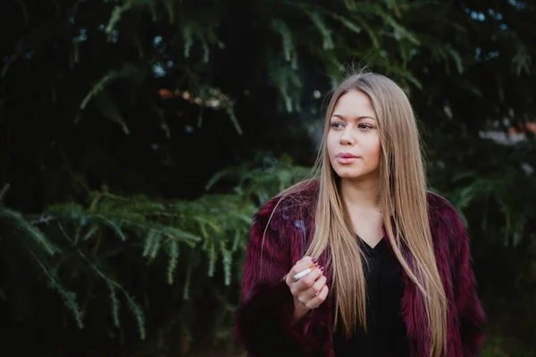 Красивая девушка курит в парке — стоковое фото