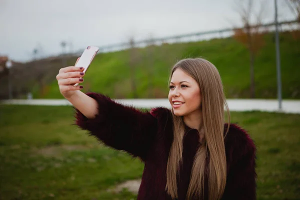 Женщина в парке с мобильного телефона — стоковое фото
