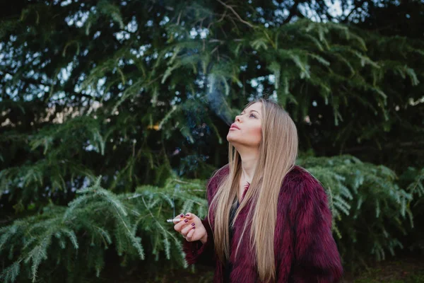 Girl with long hair smoking in park — Stock Photo, Image