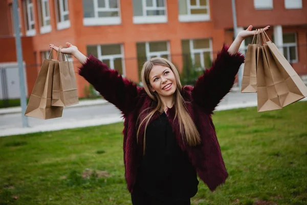 Jolie fille blonde avec des paquets de papier — Photo