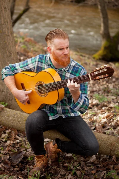 Рыжий бородатый мужчина с гитарой — стоковое фото