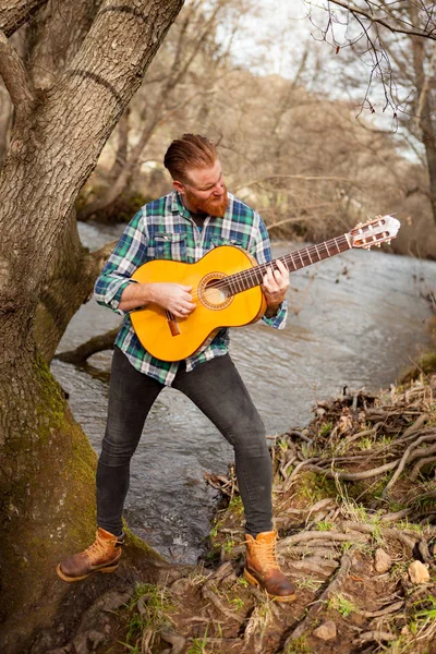 Рыжий бородатый мужчина с гитарой — стоковое фото