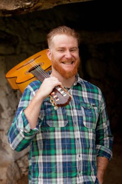 Kızıl saçlı sakallı adam gitar ile