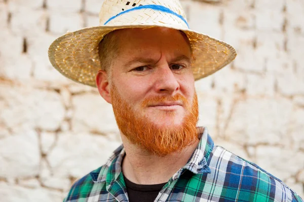 Рыжий бородатый мужчина в соломенной шляпе — стоковое фото