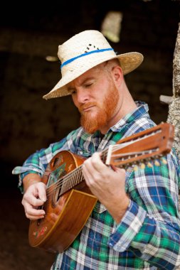 Kızıl saçlı sakallı adam gitar ile
