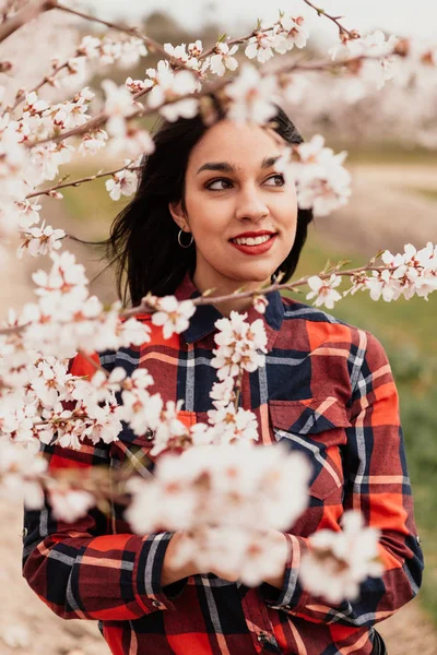 Flicka i mandelträd grenar med blommor — Stockfoto