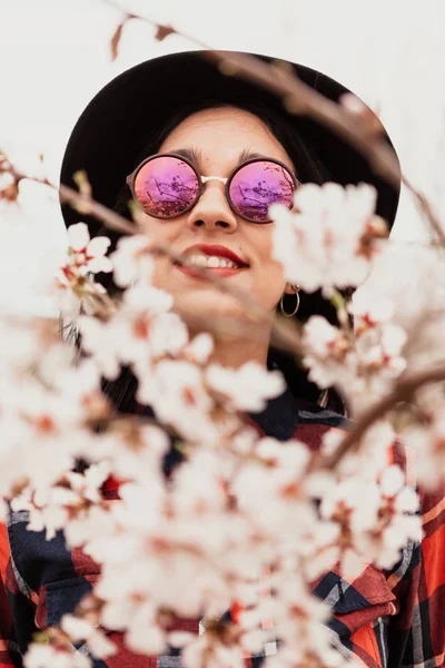 Κορίτσι σε κλάδους Αμυγδαλιά με άνθη — Φωτογραφία Αρχείου