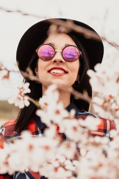 Chica en ramas de almendro con flores — Foto de Stock