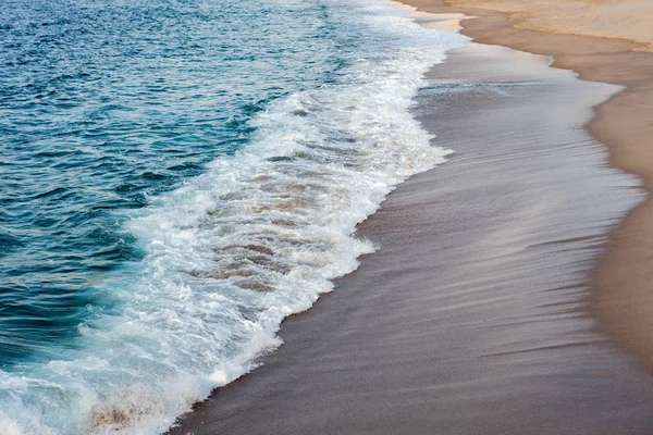 Вспененные волны, разбивающиеся на пляже — стоковое фото