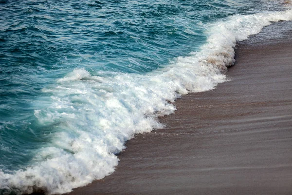 Ondas espumadas quebrando na praia — Fotografia de Stock