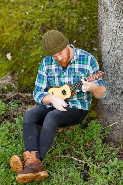 ukulele oynayan kırmızı sakallı