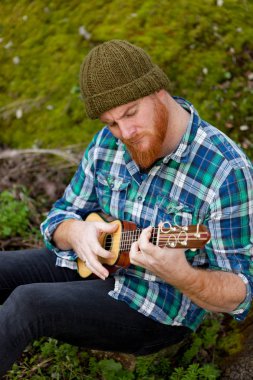 ukulele oynayan kırmızı sakallı