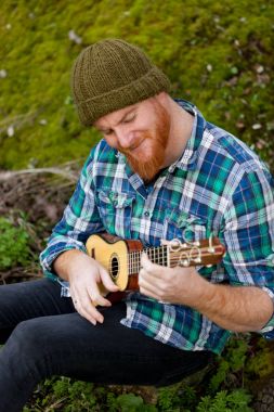 ukulele oynayan kırmızı sakallı