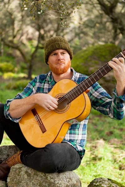 Hombre guapo con guitarra en la naturaleza —  Fotos de Stock