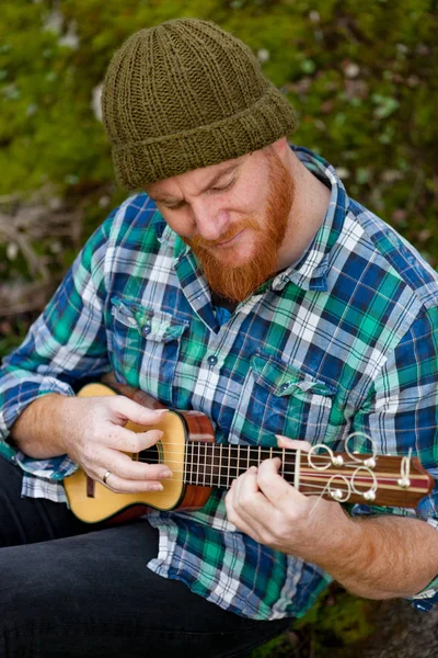 Man met rode baard ukulele spelen — Stockfoto