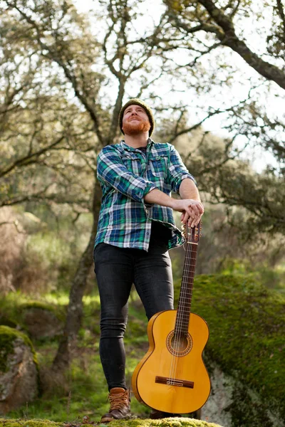 Hombre guapo con guitarra en la naturaleza —  Fotos de Stock