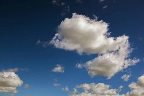 Flauschige Wolken am strahlend blauen Himmel — Stockfoto