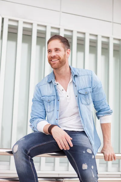 Casual guy sitting on railing — Stock Photo, Image